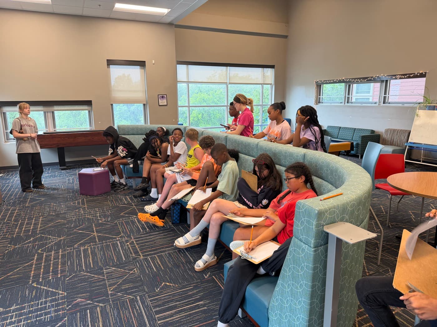A SAIL volunteer leading a discussion with students seated in a semicircle