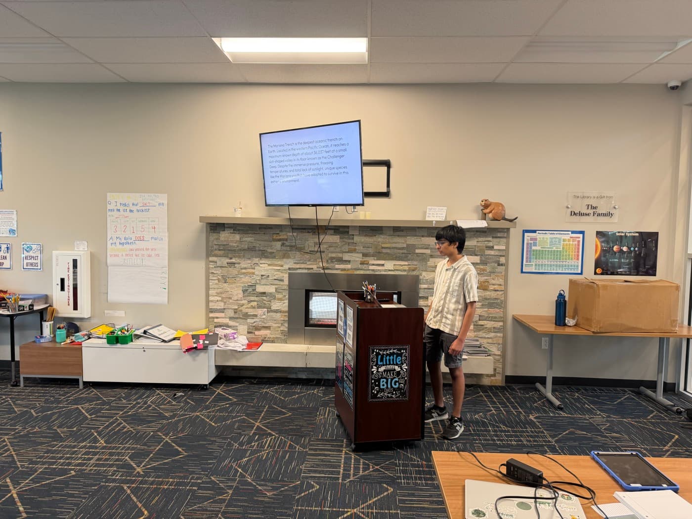 A SAIL student lead presenting from a podium beside a screen during the workshop
