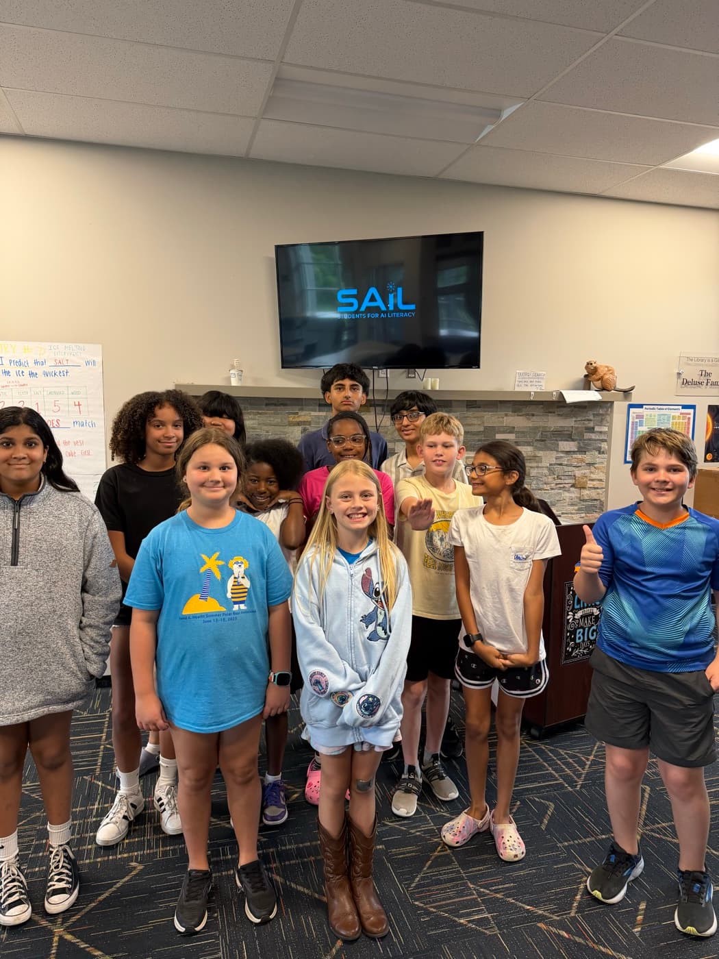 Participants smiling together beneath the SAIL Students For AI Literacy screen