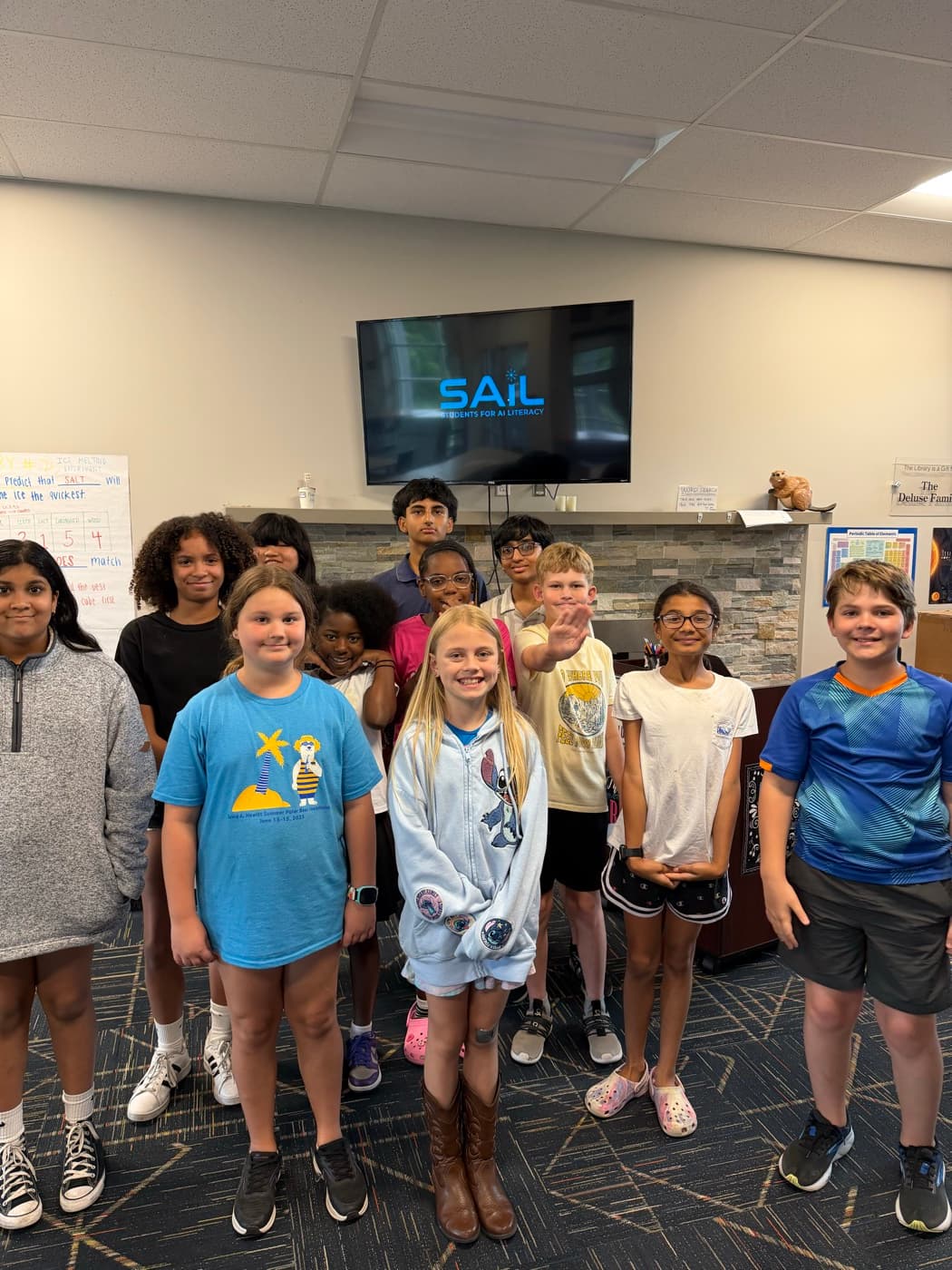 Students gathered in front of a screen displaying the SAIL logo at the Boys & Girls Club