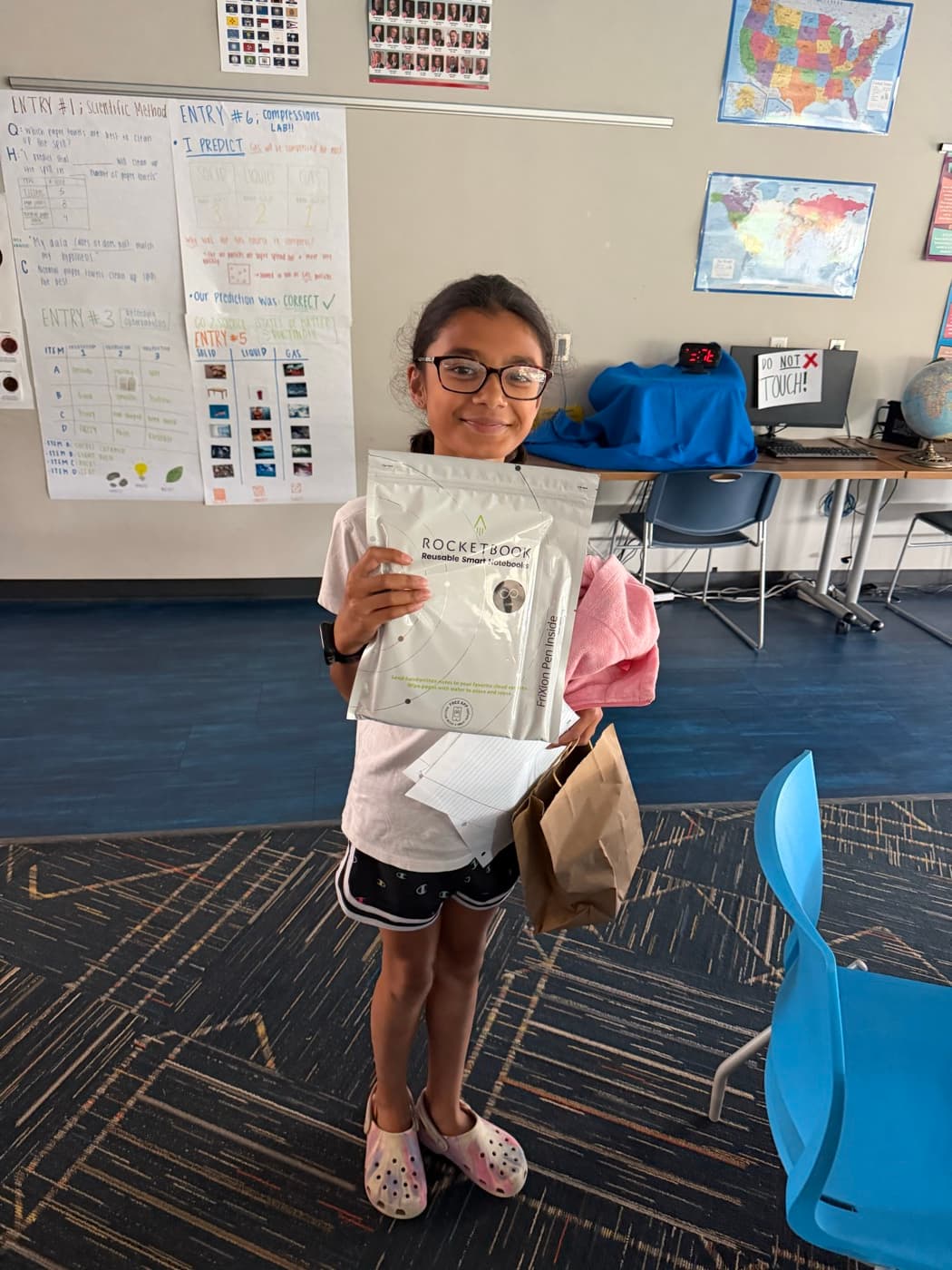 A young participant holding the reusable smart notebook she received at the session