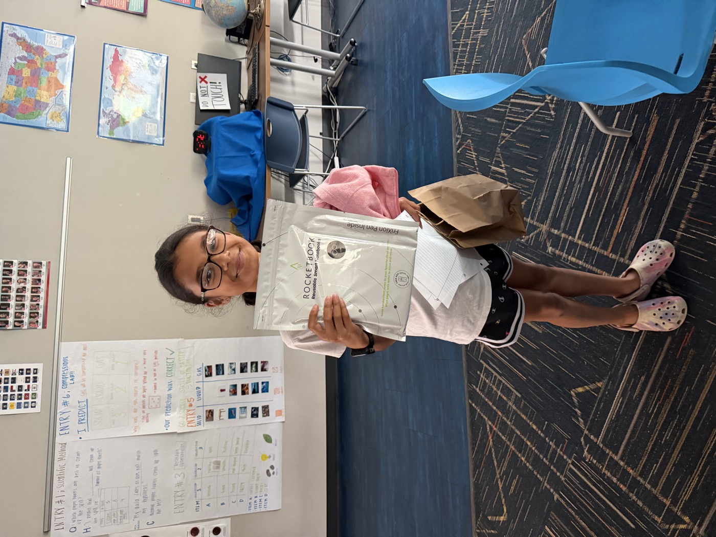 A young participant holding the reusable smart notebook she received at the session